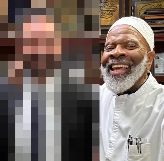 Imam smiling, with the person beside him pixelated
